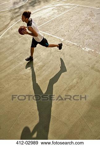Man playing basketball on court View Large Photo Image Stock Photo - Man playing basketball on court. Fotosearch