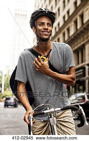 Man riding bicycle on city street View Large Photo Image Stock Photography - Man riding bicycle on city street. Fotosearch