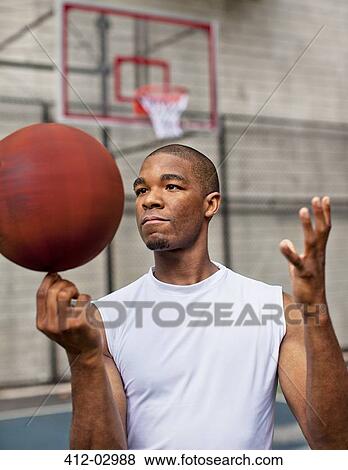 Stock Photo - Man spinning basketball on finger. Fotosearch