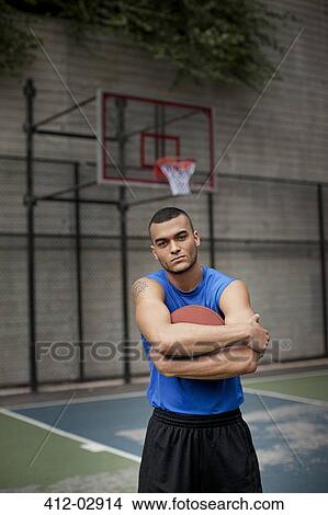 Picture - Man standing on basketball court. Fotosearch