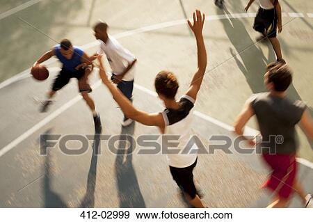 Stock Photo - Men playing basketball on court. Fotosearch