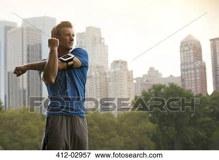 Runner stretching in urban park View Large Photo Image Stock Photo - Runner stretching in urban park. Fotosearch