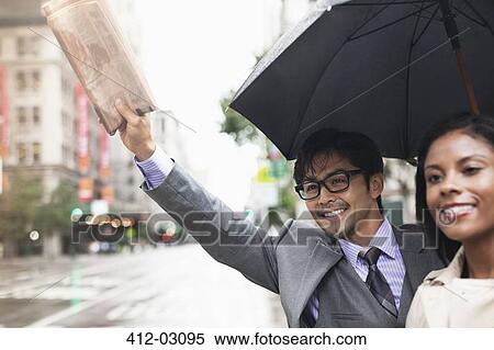 Stock Photography - Business people hailing taxi on city street. Fotosearch