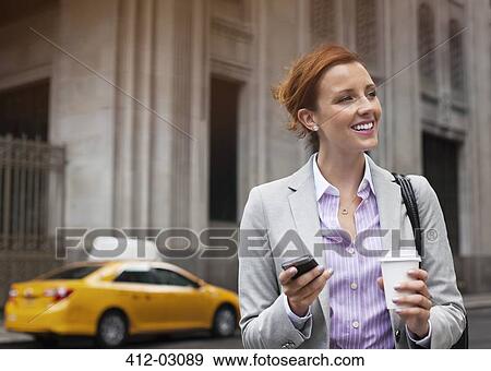 Business woman using cell phone on city street View Large Photo Image Stock Photo - Business woman using cell phone on city street. Fotosearch