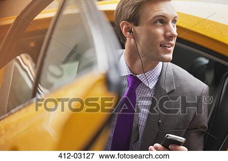 Stock Photo - Businessman climbing out of taxi. Fotosearch