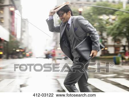 Stock Image - Businessman crossing city street. Fotosearch