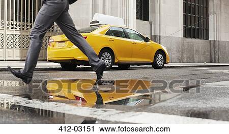 Stock Image - Businessman crossing city street. Fotosearch
