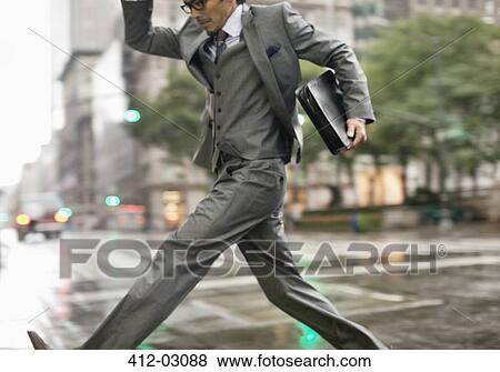 Businessman crossing city street View Large Photo Image Stock Photo - Businessman crossing city street. Fotosearch