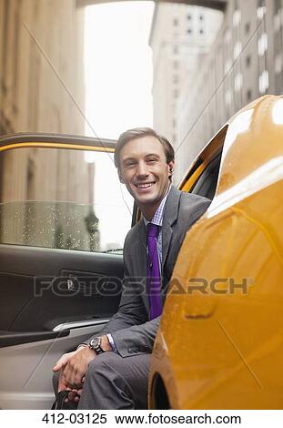 Stock Photography - Businessman sitting in taxi on city street. Fotosearch
