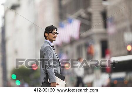 Businessman standing on city street View Large Photo Image Stock Image - Businessman standing on city street. Fotosearch