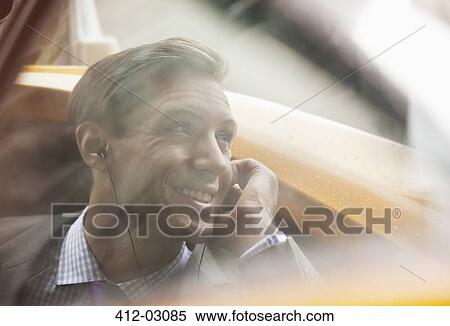 Businessman talking on cell phone in taxi View Large Photo Image Stock Photography - Businessman talking on cell phone in taxi. Fotosearch