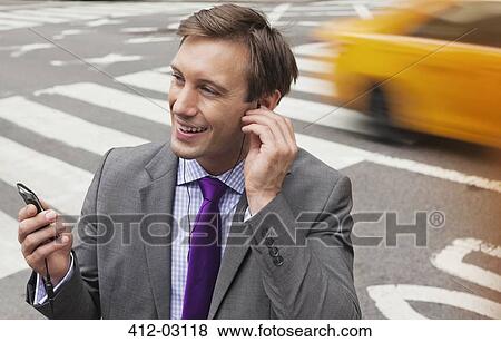 Businessman talking on cell phone on city street View Large Photo Image Stock Photo - Businessman talking on cell phone on city street. Fotosearch