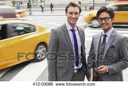 Stock Photograph - Businessmen smiling on city street. Fotosearch