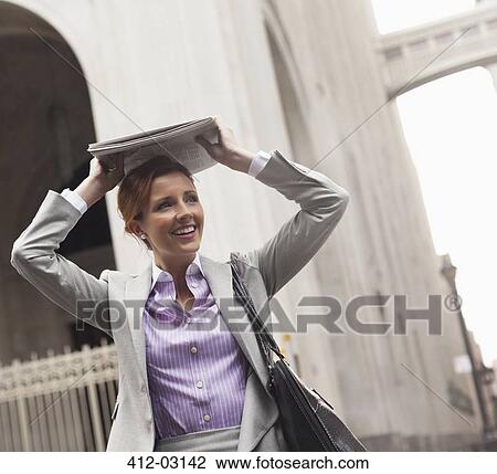 Businesswoman covering hair with newspaper View Large Photo Image Stock Image - Businesswoman covering hair with newspaper. Fotosearch