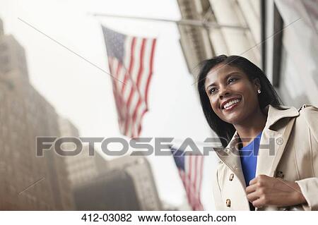 Stock Image - Businesswoman walking on city street. Fotosearch