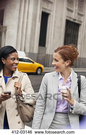Stock Photograph - Businesswomen walking on city street. Fotosearch