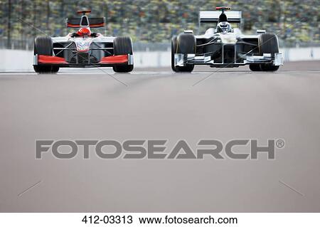 Stock Image - Race cars driving on track. Fotosearch