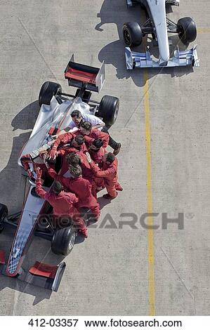 Stock Photo - Race team surrounding racer on track. Fotosearch