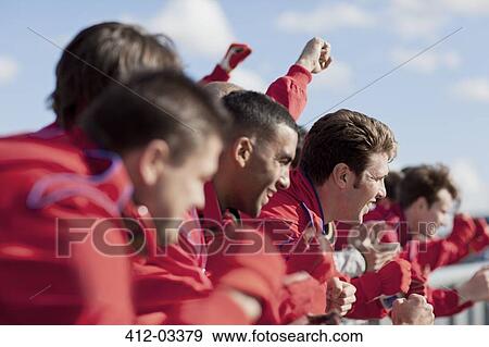Stock Photo - Race team watching from sidelines. Fotosearch