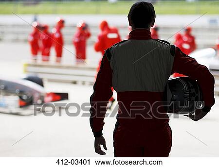 Racer carrying helmet on sidelines View Large Photo Image Stock Image - Racer carrying helmet on sidelines. Fotosearch