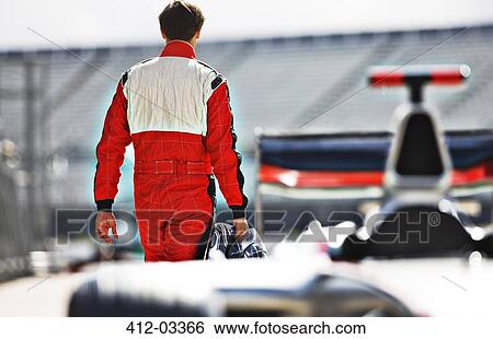 Racer carrying helmet on track View Large Photo Image Stock Photograph - Racer carrying helmet on track. Fotosearch