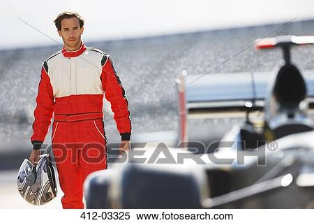 Stock Photography - Racer carrying helmet on track. Fotosearch
