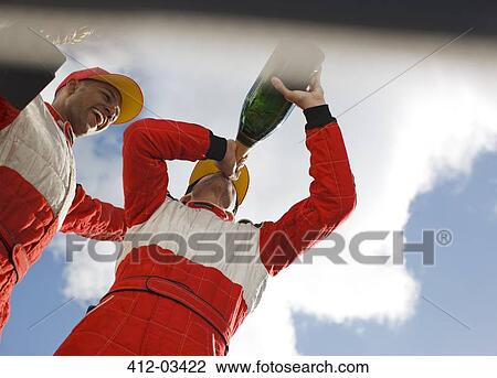 Stock Image - Racer drinking champagne on track. Fotosearch
