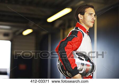 Racer holding helmet in garage View Large Photo Image Stock Image - Racer holding helmet in garage. Fotosearch