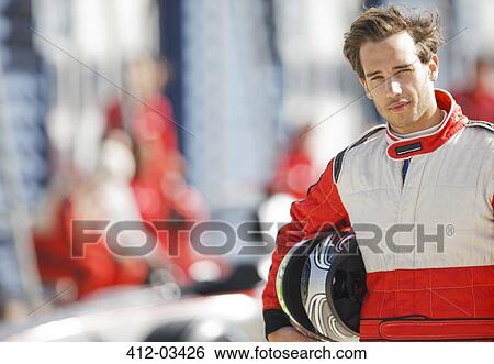 Stock Photograph - Racer holding helmet on track. Fotosearch