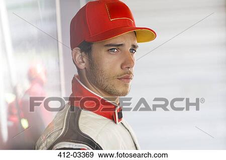 Stock Photo - Racer standing in garage. Fotosearch