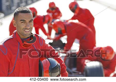 Racer standing with team in pit stop View Large Photo Image Stock Image - Racer standing with team in pit stop. Fotosearch