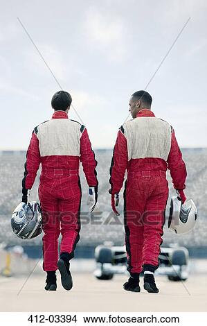 Picture - Racers carrying helmets on track. Fotosearch