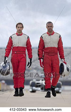 Racers carrying helmets on track View Large Photo Image Stock Image - Racers carrying helmets on track. Fotosearch