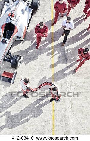 Stock Image - Racers shaking hands on track. Fotosearch