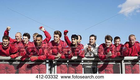 Stock Image - Racing team cheering on sidelines. Fotosearch