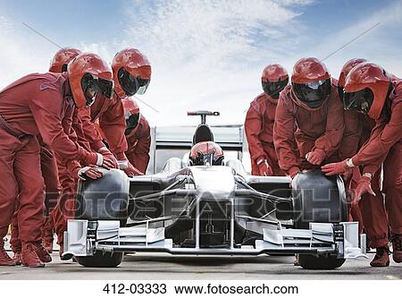 Stock Image - Racing team working at pit stop. Fotosearch