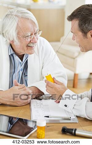 Doctor giving medication to older patient at house call View Large Photo Image Stock Image - Doctor giving medication to older patient at house call. Fotosearch