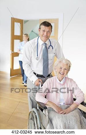 Doctor pushing older patient in wheelchair View Large Photo Image Stock Photography - Doctor pushing older patient in wheelchair. Fotosearch
