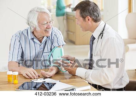 Doctor testing older patient's blood pressure at house call View Large Photo Image Stock Photograph - Doctor testing older patient's blood pressure at house call. Fotosearch
