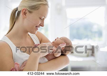 Mother cradling newborn baby View Large Photo Image Picture - Mother cradling newborn baby. Fotosearch