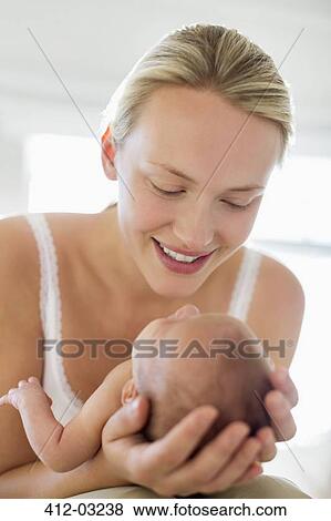 Stock Photo - Mother cradling newborn baby. Fotosearch