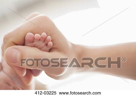 Mother cradling newborn baby's foot View Large Photo Image Stock Photography - Mother cradling newborn baby's foot. Fotosearch