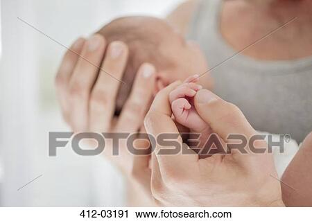 Mother cradling newborn baby's hand View Large Photo Image Stock Image - Mother cradling newborn baby's hand. Fotosearch