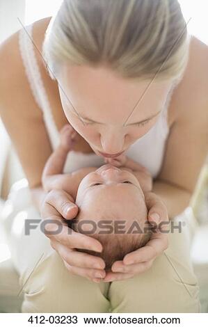 Mother kissing newborn baby View Large Photo Image Stock Image - Mother kissing newborn baby. Fotosearch