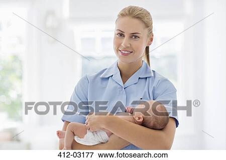 Nurse holding newborn baby in hospital View Large Photo Image Stock Photo - Nurse holding newborn baby in hospital. Fotosearch