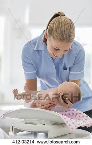 Nurse weighing newborn baby View Large Photo Image Picture - Nurse weighing newborn baby. Fotosearch