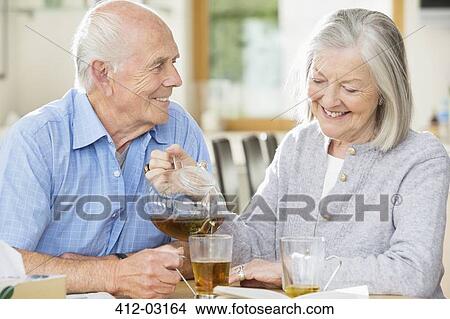 Picture - Older couple having tea together indoors. Fotosearch