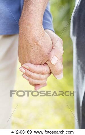 Older couple holding hands outdoors View Large Photo Image Stock Photo - Older couple holding hands outdoors. Fotosearch