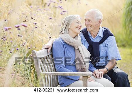 Older couple relaxing on park bench View Large Photo Image Stock Image - Older couple relaxing on park bench. Fotosearch