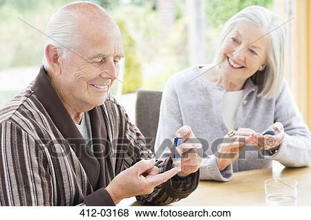 Stock Photo - Older couple testing blood sugar together. Fotosearch